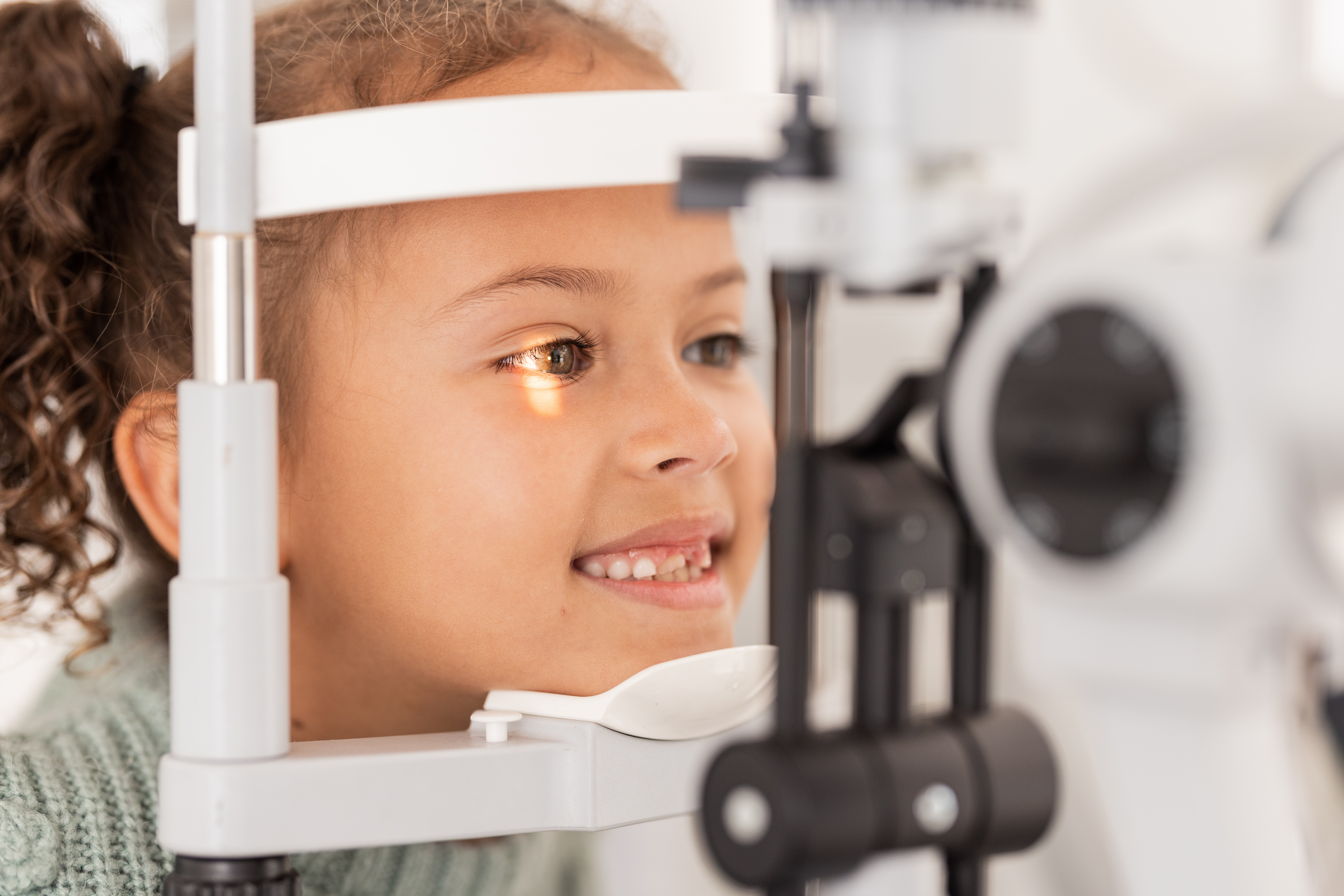 Vision, test and girl for eye exam in the opthalmologist office with equipment for glasses. Optics, examination and female child testing for eyecare health or wellness for optometry for healthcare Vision, test and girl for eye exam in the opthalmologist office with equipment for glasses. Optics, examination and female child testing for eyecare health or wellness for optometry for healthcare.
